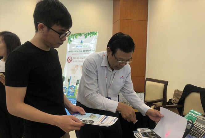Doanh nghiệp rất bức xúc trước sản phẩm bị làm giả nhưng cũng ngại lên tiếng. Ảnh: chiếu đèn laser lên tem chống giả để phân biệt hàng thật - giả