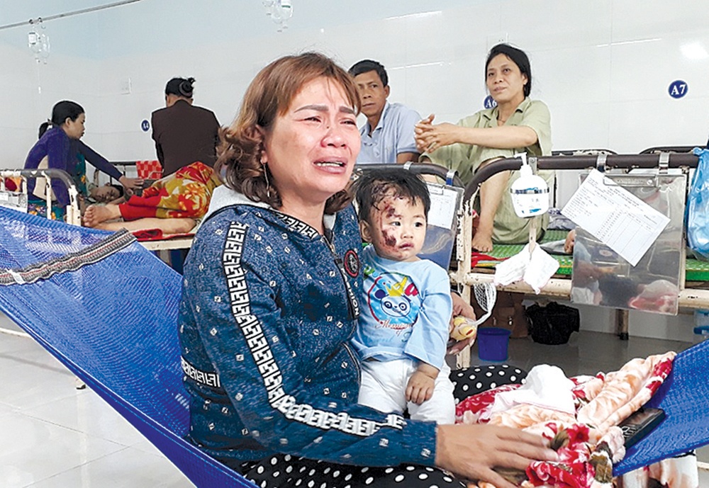 Bà ngoại khóc nấc bên cháu Huỳnh Trịnh Băng Tâm (9 tháng tuổi) đang điều trị tại bệnh viện. Con gái và con rể bà bị thương rất nặng. Người cháu còn lại 5 tuổi đã qua đời mà bà không thể đi đưa tiễn