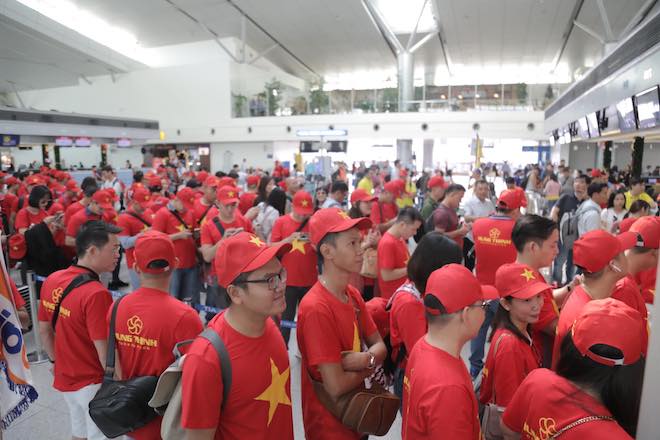 Cổ động viên bóng đá rực sắc đỏ khi xếp hàng làm thủ tục xuất cảnh tại sân bay Tân Sơn Nhất.