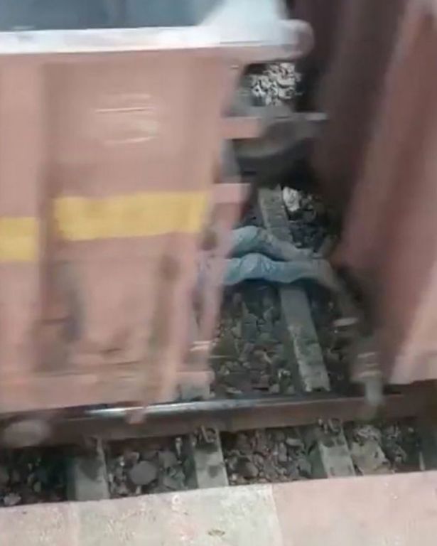 Bé trai nằm sát bên đường ray