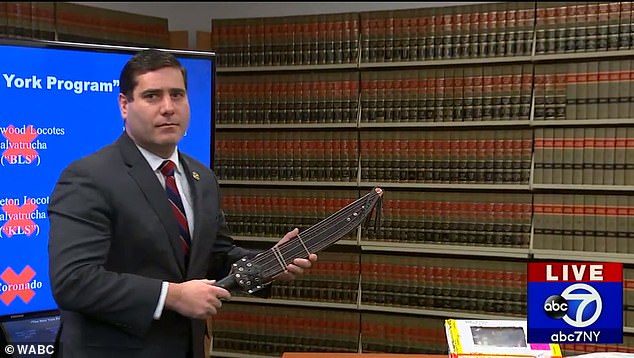 Luật sư Tim Sini cầm trên tay một con dao rựa được thu giữ từ cá thành viên MS-13 (Ảnh: WABC)