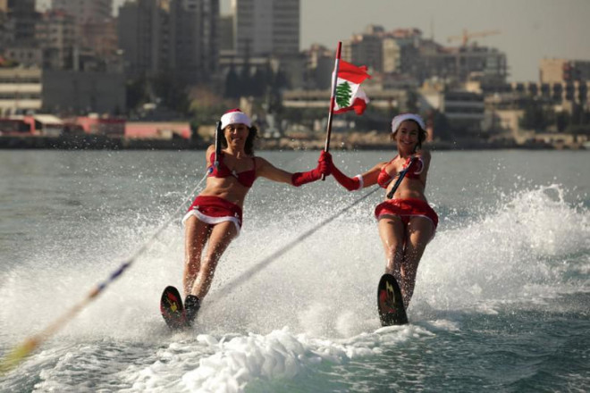 Hai phụ nữ Lebanon lướt sóng trong trang phục bikini Noel ở vịnh Jounieh, Beirut năm 2013.