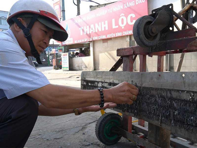 Ông Đinh Minh Cảnh với công việc hút đinh tình nguyện mỗi ngày. Ảnh: MT