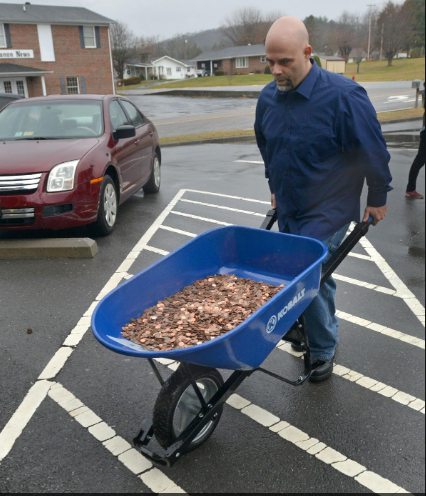 Nick Stafford đã mang 5 xe cút kít chở 300.000 đồng tiền xu nặng 725kg đến Cục quản lý xe cơ giới địa phương để đóng thuế. Ảnh HC