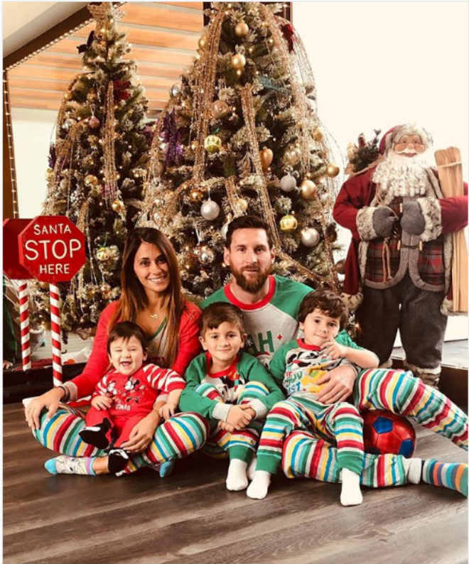 Vợ chồng Antonella Roccuzzo và Lionel Messi cùng 3 cậu con trai Thiago, Mateo và Ciro diện những bộ quần áo với màu sắc sặc sỡ và bắt mắt chụp ảnh bên cây thông và bức tượng ông già Noel trong tổ ấm hạnh phúc của họ