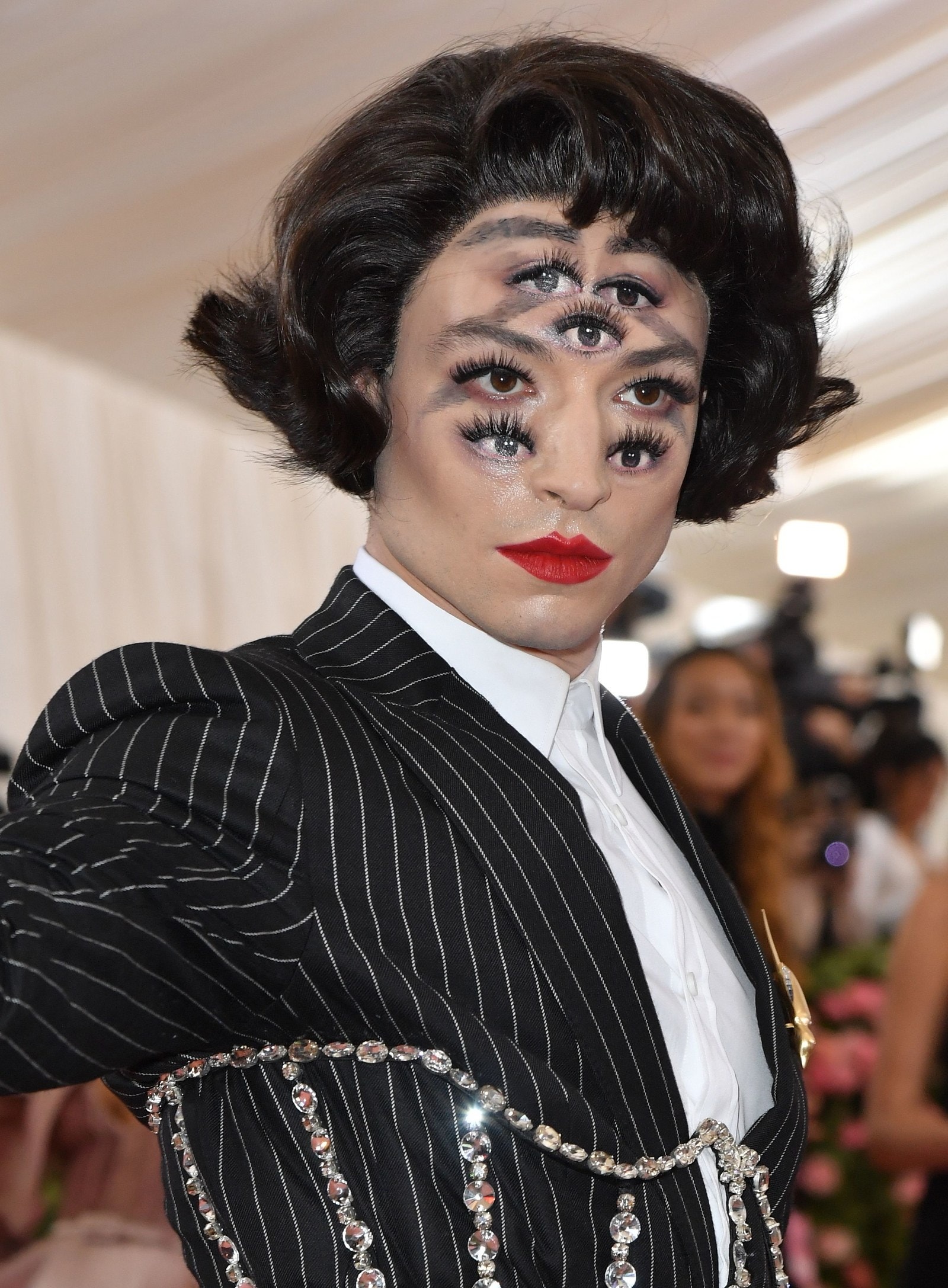 Ezra Miller tại Met Gala, 2019: Tại Met Gala năm nay, Ezra Miller đã khiến những người tham dự rơi vào tình trạng chóng mặt khi anh ta đến với một đôi môi đỏ tươi và khuôn mặt được vẽ bằng năm nhãn cầu để tạo hiệu ứng ảo ảnh quang học. Thể hiện tinh thần của đêm tiệc, anh tiếp tục hóa thân thành một nàng thơ làm đẹp thích thử nghiệm những sự mạo hiểm.