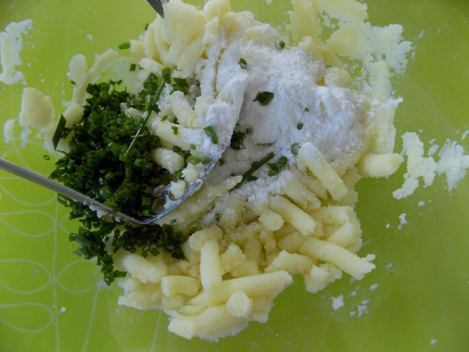 Sau đó cho hành lá thái nhỏ + muối + bột nêm và bột khoai tây vào, mang bao tay trộn đều.