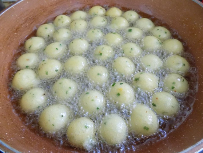 Bắc chảo dầu lên bếp, chờ dầu nóng thì cho các viên khoai vào chiên ( nên để lửa hơi lớn một chút, nếu lửa quá nhỏ thì khoai dễ bị nát). Trong thời gian chiên, thỉnh thoảng dùng đũa trở các viên khoai để khoai chín và vàng giòn đều. 