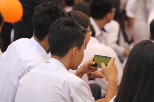 Hầu hết học sinh THPT mang theo điện thoại và sử dụng tại trường học. (Ảnh: NLĐ).