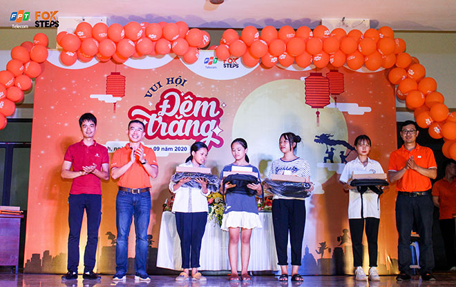 Ông Hoàng Việt Anh - Tổng Giám đốc FPT Telecom (áo cam thứ 2 sang bên trái) trao quà trung thu cho các em nhỏ tại sân chơi FoxSteps khu vực Đông Anh, Hà Nội