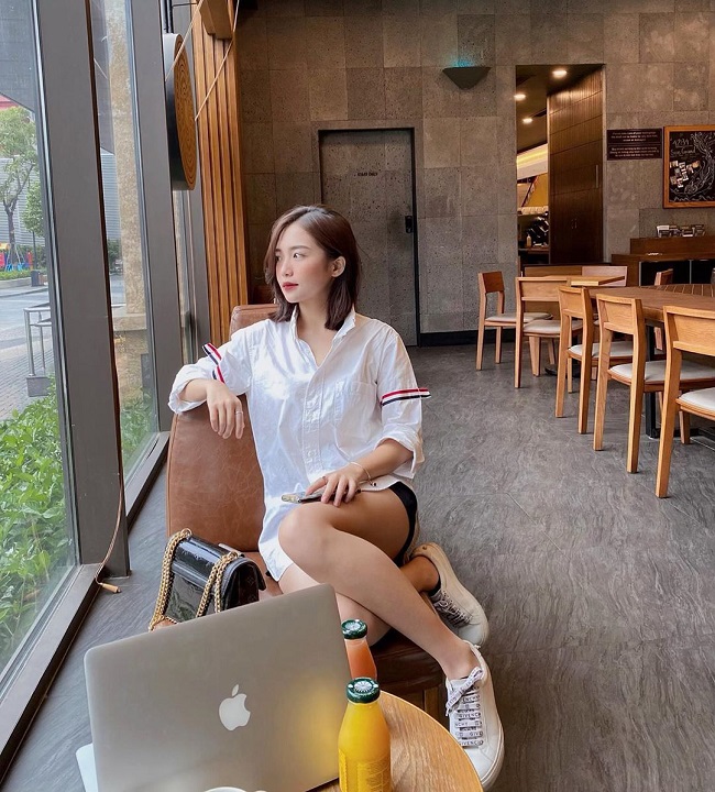 Khi đi cafe với bạn bè, hot girl sinh năm 1997 chuộng diện mốt áo sơ mi oversize phối với quần short và sneaker. Mái tóc tỉa layer cắt ngang vai giúp cô nàng tăng thêm vẻ năng động, trẻ trung.

