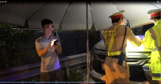 Tài xế T.L liên tục bấm điện thoại khi CSGT lập biên bản xử lý