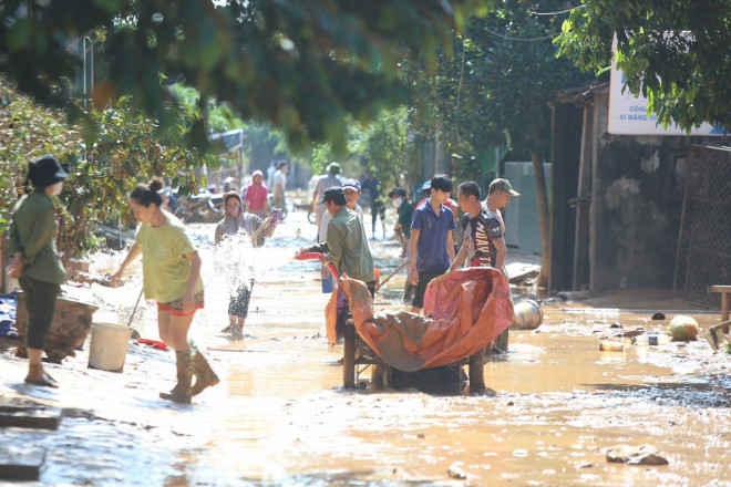 Lũ rút xuống, người dân xã Hiền Ninh, huyện Quảng Ninh (Quảng Bình) dọn dẹp vệ sinh, từng xe bùn được cào đổ. Màu bùn đất đỏ lấm lem trôi theo nước lũ đục ngầu.
