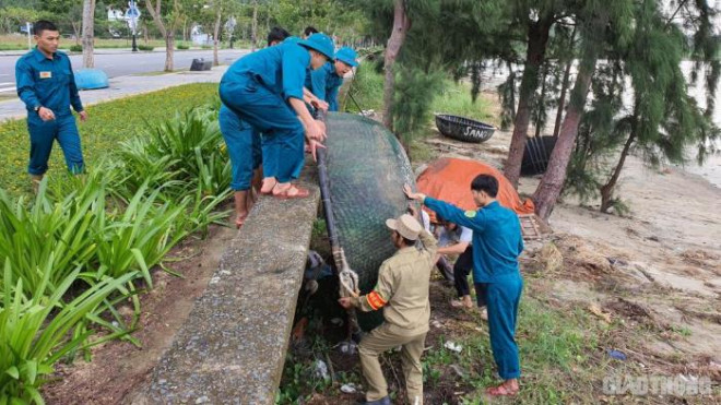 Dân quân tự vệ hỗ trợ ngư dân đưa thuyền thúng lên bờ tránh bão Bão số 9 cách đảo Song Tử Tây khoảng 230km