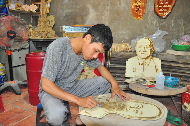 Anh Nguyễn Vũ Linh đang làm tranh chân dung Bác Hồ bằng lá thốt nốt. - Ảnh: Hòa Hội