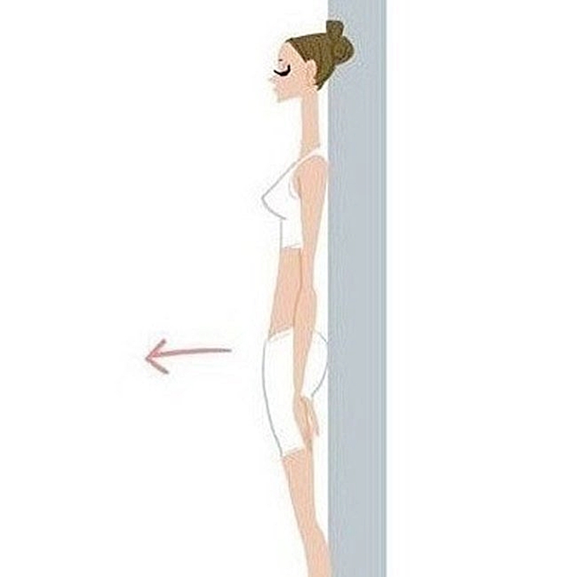 Kiên trì dựa lưng vào tường 5 phút mỗi ngày giúp bạn hình thành thói quen đứng thẳng.