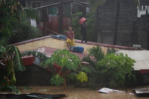 Nhiều người dân Phillippines bị mắc kẹt trên mái nhà. Ảnh: Reuters