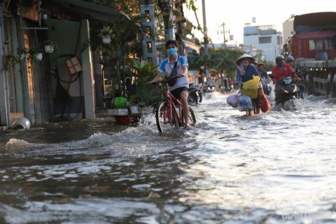 Triều cường đạt đỉnh, người dân TP.HCM vật vã lội &#34;biển nước&#34; về nhà - 5