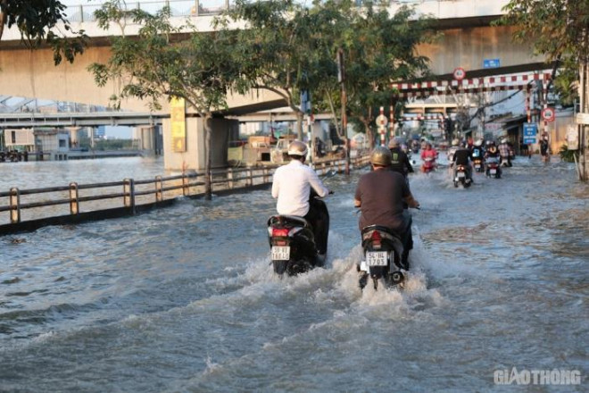 Triều cường đạt đỉnh, người dân TP.HCM vật vã lội &#34;biển nước&#34; về nhà - 4