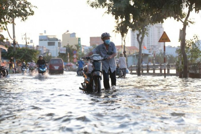 Triều cường đạt đỉnh, người dân TP.HCM vật vã lội &#34;biển nước&#34; về nhà - 7