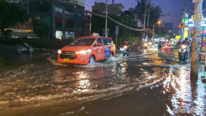 Triều cường đạt đỉnh, người dân TP.HCM vật vã lội &#34;biển nước&#34; về nhà - 10