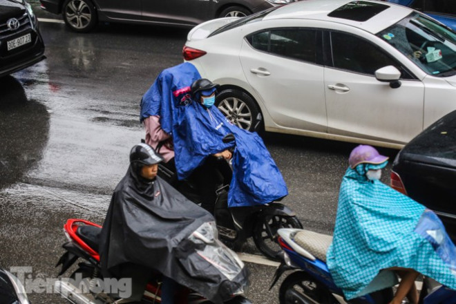 Hầu hết người tham gia giao thông đều "ẩn mình" dưới áo mưa.