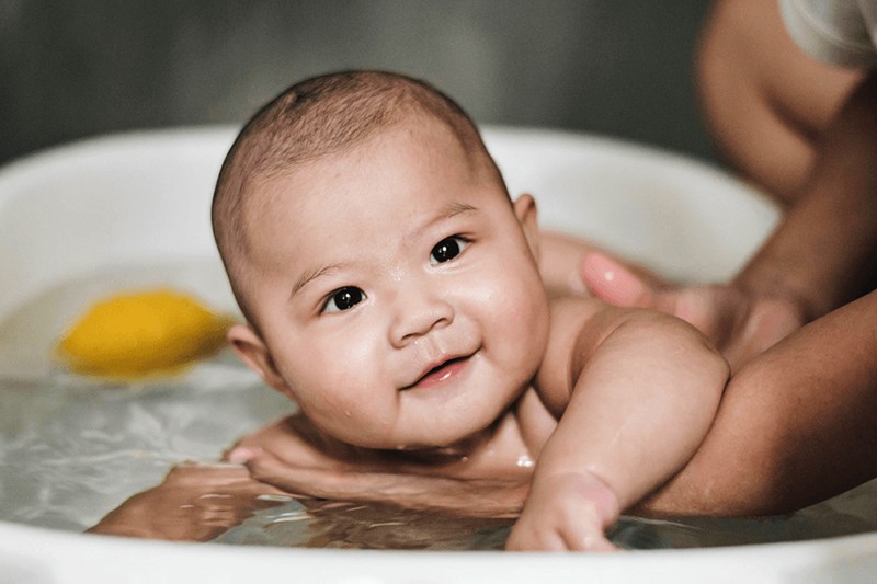 Cha mẹ nên tắm cho trẻ bằng nước ấm, ở nơi kín gió, không nên tắm lâu để con không bị nhiễm lạnh