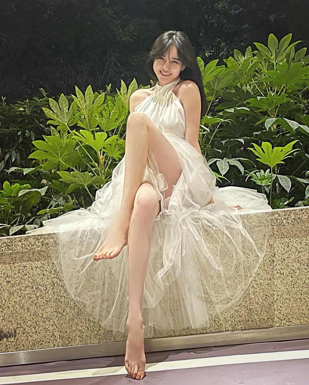 Cô gái Hàn Quốc mặc chiếc váy dáng dài bồng bềnh,&nbsp;cổ yếm khoe đôi chân nuột nà.