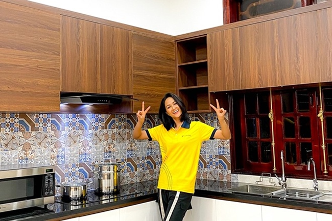 Phòng bếp rộng rãi, nhiều tiện ích trong căn nhà mới của H'Hen Niê. Hoa hậu cho biết, cô đã đập đi một phòng ngủ để cơi nới mở rộng không gian bếp.  Người đẹp chú trọng vật liệu gỗ vừa đảm bảo được tính hiện đại của căn nhà, vừa hợp với phong cách Tây Nguyên.
