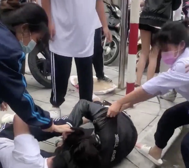 Ba nữ sinh Trường THPT Huỳnh Thúc Kháng (Hà Nội) đánh nhau trước cổng trường. Ảnh: T.L