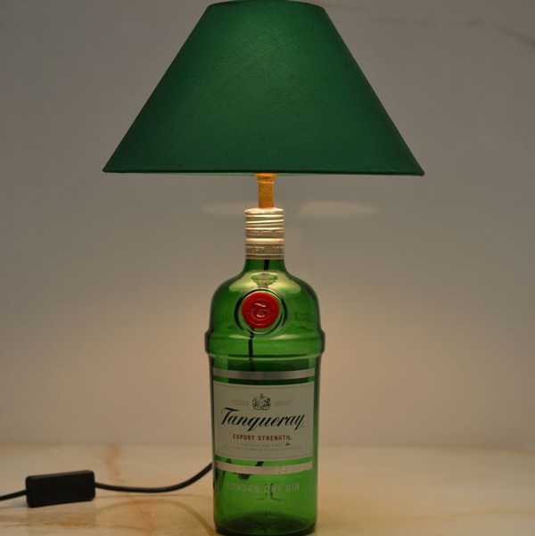 Chiếc đèn để bàn được làm từ chai rượu bằng thủy tinh.