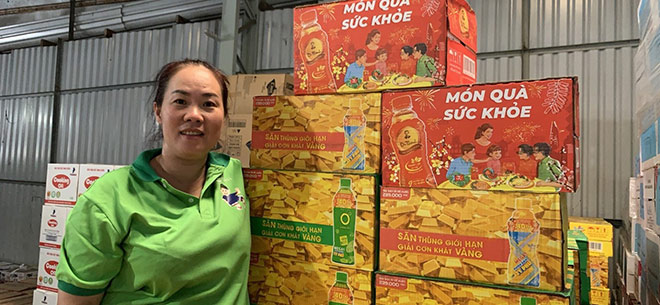 Chị Kim Mai vui mừng bên cạnh quầy tạp hoá của gia đình