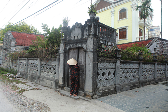 Toàn cảnh ngôi nhà nhìn từ bên ngoài. Tường rào được đục đẽo hình đồng tiền âm dương. Trên cổng chào đề năm khánh thành nhà là 1934, bên trên có bức cuốn thư khắc chữ Nho. Cổng ra vào nhà, bên trên có vọng gác cũng được làm từ đá xanh.