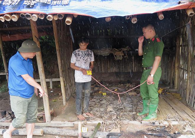 Cán bộ điều tra dẫn giải đối tượng Điêu Văn Vững đi thực nghiệm hiện trường vụ án.