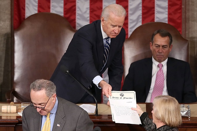 Ông Biden trao giấy chứng nhận phiếu bầu cho nghị sĩ của các bang trong phiên họp kiểm phiếu của QUốc hội vào ngày 4.1.2013.