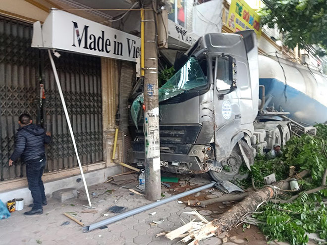 Chiếc xe bồn bất ngờ lao lên vỉa hè tông đổ nhiều biển hiệu nhà dân ven đường Ngọc Hồi.