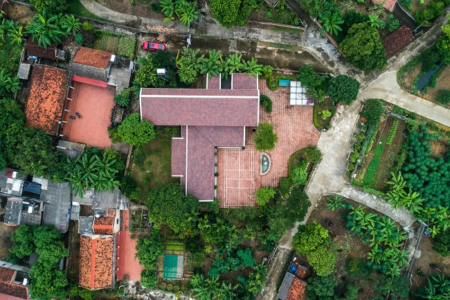 Toàn cảnh X – House nhìn từ trên cao xuống với những đường nét đậm chất làng quê Việt: gạch đỏ, mái ngói và những hàng cây xanh mát quanh nhà.
