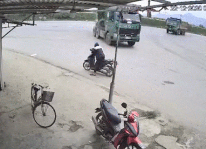 Video: Đang đỗ xe máy bên đường bị lốp xe tải văng vào người - 1