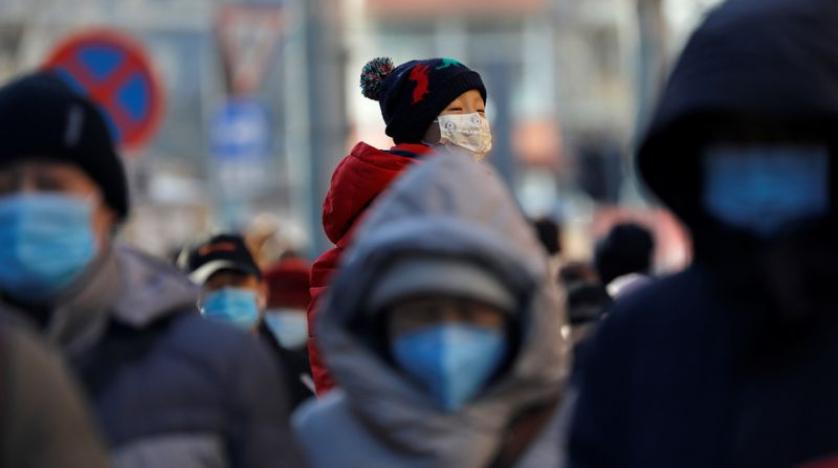 Người dân đeo khẩu trang đi lại trên đường phố ở Bắc Kinh hôm 8/12. Ảnh: Reuters