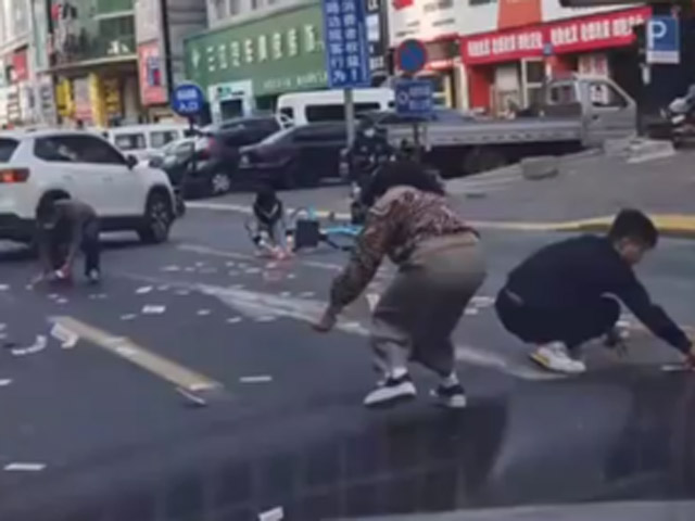 Bạn trẻ - Cuộc sống - Người phụ nữ bất cẩn làm rách túi khiến tiền bay khắp phố, diễn biến sau đó gây bất ngờ