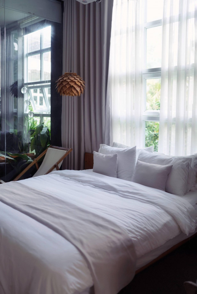 Trong khi đó phòng ngủ master có thêm chiếc máy chiếu phục vụ việc xem phim. Cửa sổ rộng mở đón ánh sáng ban mai và từ đây có thể nhìn ra khoảng sân vườn xanh mát.