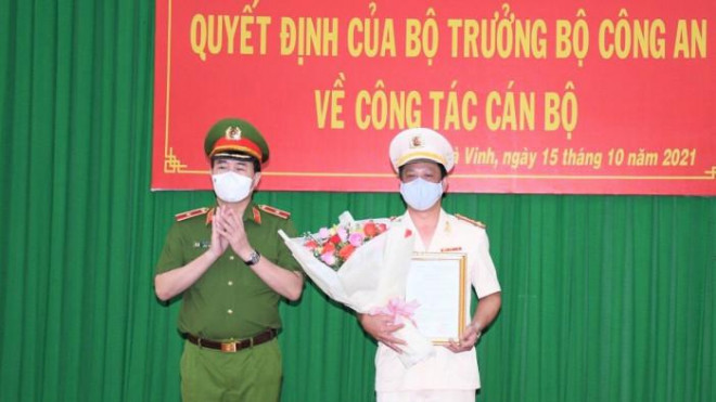 Thiếu tướng Lê Quốc Hùng, Thứ trưởng Bộ Công an trao quyết định và hoa chúc mừng Đại tá Trần Xuân Ánh. Ảnh H.G