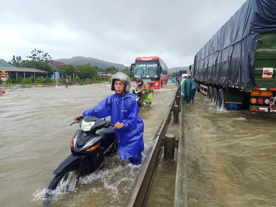 Quốc lộ 1A đoạn qua xã Lộc Trì, huyện Phú Lộc (Thừa Thiên - Huế) bị ngập, người đi xe gắn máy phải dắt bộ - Ảnh: Quang Tám