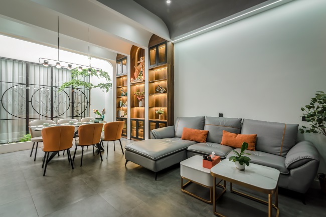 Phòng khách nhẹ nhàng và ấm cúng với bộ ghế sofa màu xám êm ái, sát bên là hệ tủ lớn dạng vòm độc đáo. Bên trong hệ tủ được bố trí hệ thống đèn led, vừa tạo điểm nhấn vừa có đủ ánh sáng cho không gian.&nbsp;
