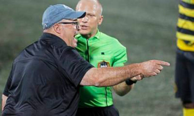Ông Bob Lilley, HLV trưởng của Pittsburgh Riverhounds (đội mũ) phàn nàn với trọng tài chính Jonathan Bilinski