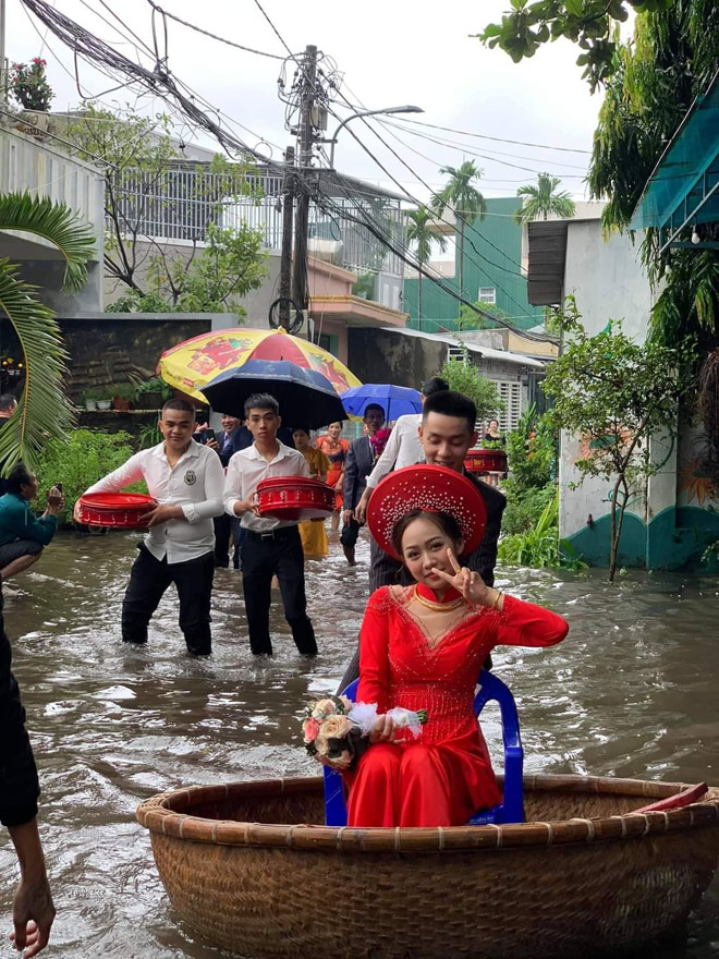 Cô dâu Khánh Vy được chú rể đẩy bằng thuyền thúng, di chuyển qua đoạn đường ngập nước. Ảnh:&nbsp;Nguyễn Lu Kỳ.
