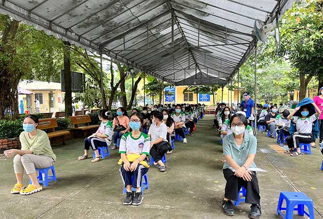 Từ sáng sớm, hàng trăm học sinh tập trung tại điểm tiêm Trường Tiểu học thị trấn Củ Chi chờ khám sàng lọc trước khi tiêm vắc xin