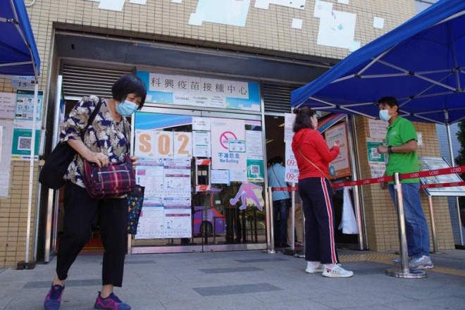 Người dân Hong Kong xếp hàng chờ để được hướng dẫn vào tiêm vaccine ngừa COVID-19. Ảnh: SCMP