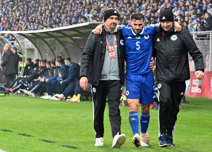 Kolasinac cần tới sự giúp đỡ của 2 người mới có thể rời sân 