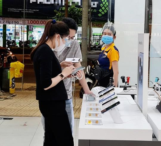 Người dân tuân thủ đeo khẩu trang khi mua hàng trong một cửa hàng điện thoại di động